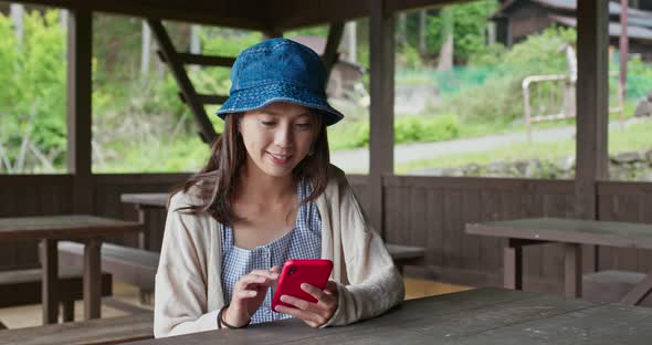 Woman use of mobile phone in the wooden house