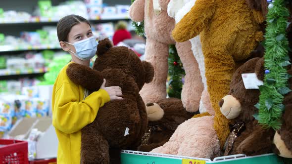 Girl hugging teddy bear in mall during pandemic