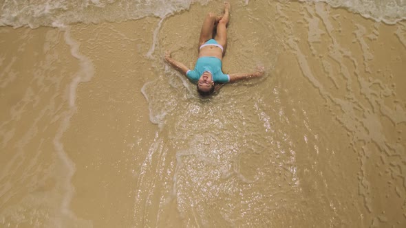 Woman Lying on Shallow Water Sea