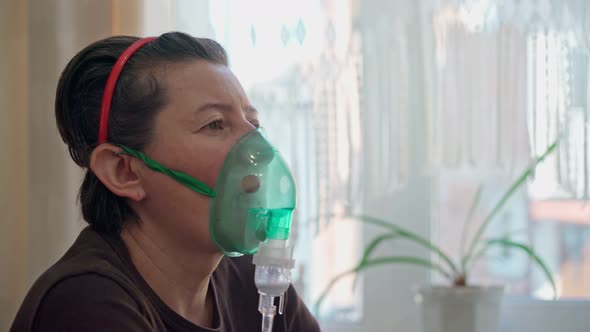 A European Woman at Home Carries Out Inhalation Inhalation of Oil Vapors Oxygen Through a Mask