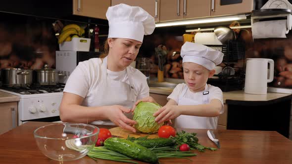 Mother with Her Son Prepare Vegetable Salad Together Cut Fresh Cabbage