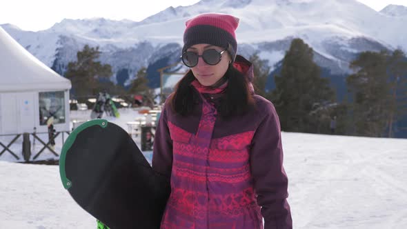 Girl Snowboarder with Snowboard on Mountain Top on Ski Resort, Winter Sports and Winter Vacation