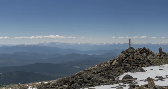 Time Lapse of Cloudscape Behind of the Mountains Top. Snow, Rocks, Cliffs and Deep Blue Sky. High