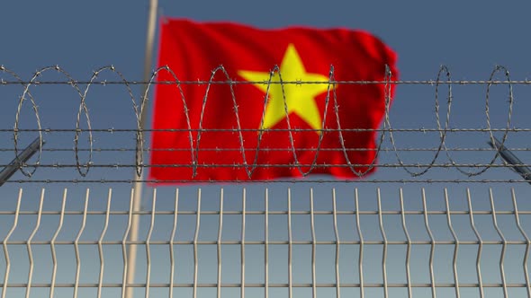 Waving Flag of Vietnam Behind Barbed Wire Fence