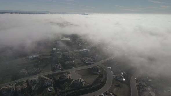 Flying over a neighborhood of Central Valley  in California in emerging fog.