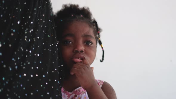 African American little girl is crying and stand near her mother and look around