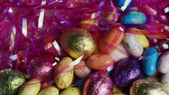 Rotating shot of colorful Easter candies on a bed of easter grass