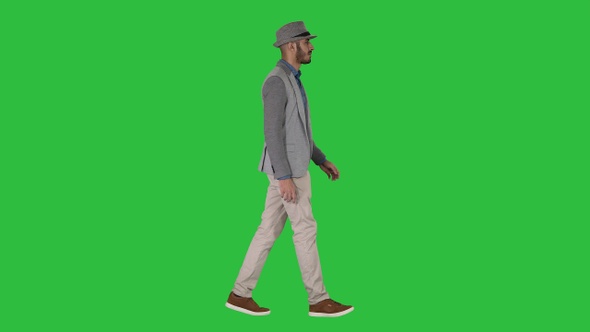 Casual arabic man in hat walking on a Green Screen, Chroma Key