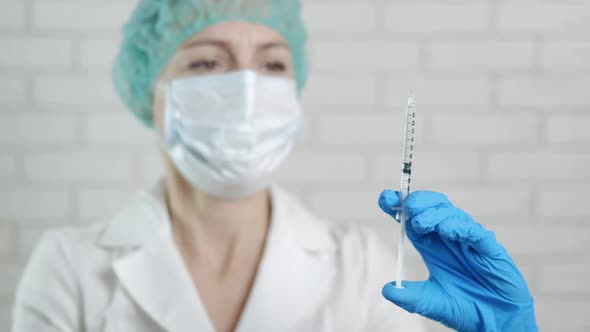 A medic with a vaccine in a syringe.