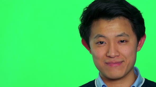 A Young Asian Man Smiles at the Camera - Green Screen Studio - Closeup