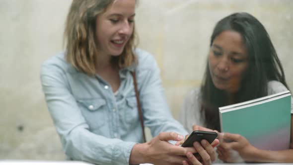 Women enjoying multimedia smartphone together