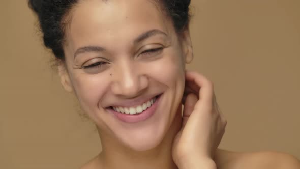 Beauty Portrait of Young African American Woman with Healthy Skin Looking at Camera and Smiling