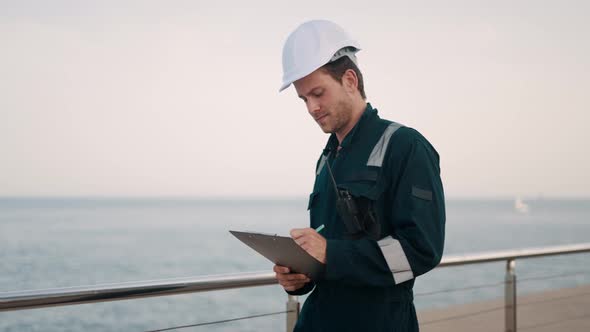 Young Male Marine Deck Officer or Port Worker Doing Vessel Inspection in Seapor