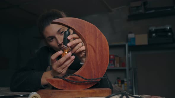 Carpenter screwing in light bulb in lamp