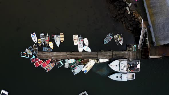 drone aerial lift shot of dock with small boats and lobster fishing vessel 4k 30p