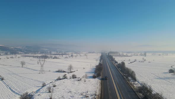 Cars driving down the snowy highway