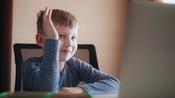 Schoolboy Raising Hand Talking with Online Tutor on Social Distance Video Conference Call e Learning