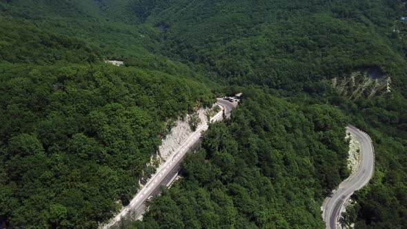 Aerial View From Above of Curve Road with a Car on the Mountain with Green Forest in Russia