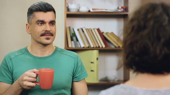 Two Adult Business Colleagues Communicating, Drinking Coffee on Lunch Break