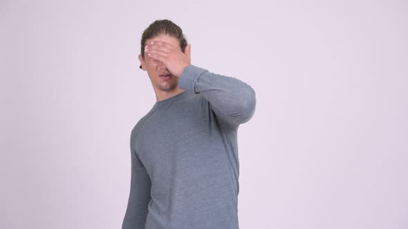 Stressed Man Covering Eyes Against White Background