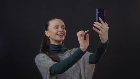 Happy Adult Lady with Long Ponytail Enjoys Taking Selfie