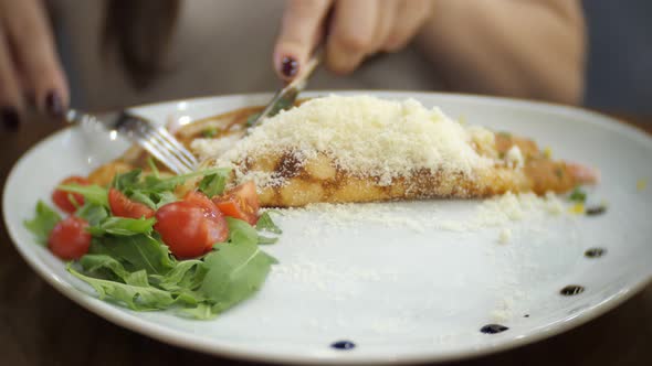 Pretty Woman Is Dining Pancakes with Ham, Cheese, Greens and Tomatoes.