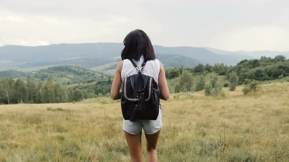 Girl Travels Mountains with a Backpack