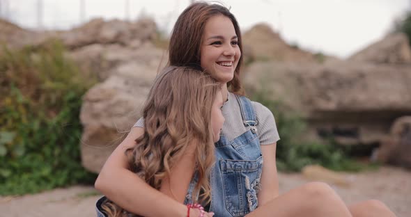 Two Cute Sisters Talks at the Beach of the Sea