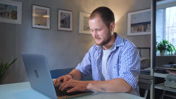 Man is working typing use laptop computer at home office at dark night. Social media facebook 