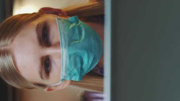 Medium Shot of Computer Monitor and Woman in Medical Mask Reading Something on It