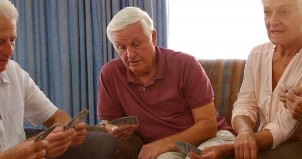 Group of senior friends playing cards