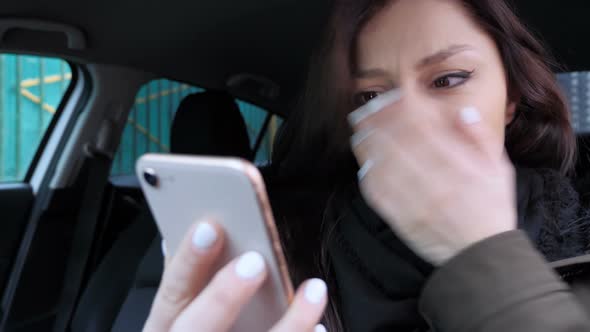 Woman Upset by Loss, while Using Smartphone in Car