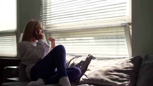 A Relaxed Woman Using Her Smartphone Surfing Social Networks, Checking News, Playing Mobile Games or