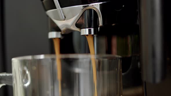 Close Up View of Pouring Liquid Coffee From Automatic Coffee Machine with Chromed Nozzle Into