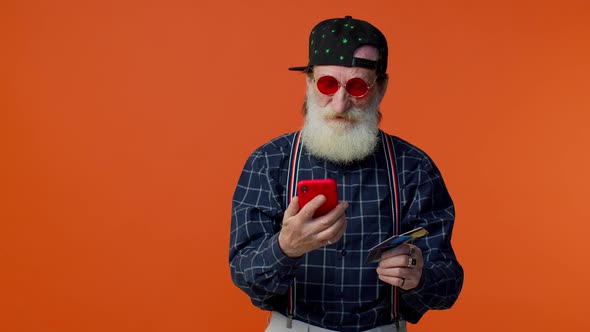 Senior Old Stylish Bearded Man Using Credit Plastic Card and Smartphone Purchases Online Shopping