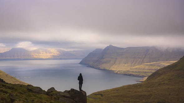 Man Watching Clouds Move Over Fjord