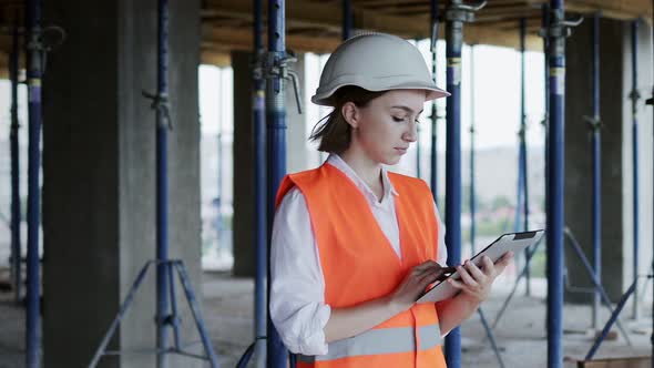 Engineer or Architect working at Construction Site. A woman with a tablet at a construction site