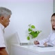 Asian female doctor interrogates an elderly man in a hospital office.health care concept - VideoHive Item for Sale