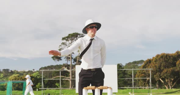 Cricket umpire making signs standing on a cricket pitch