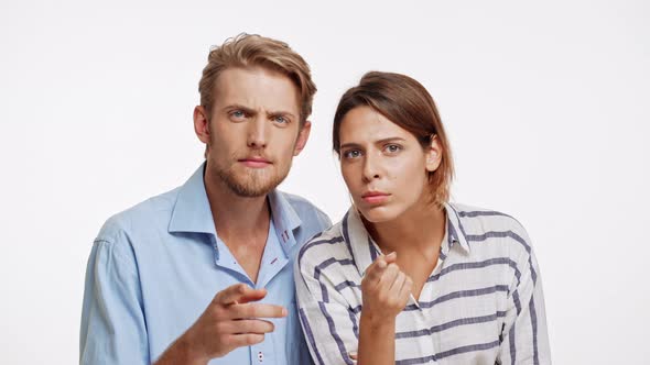 Young Caucasian Pair on White Background Looking at Camera Choosing and Lure Someone