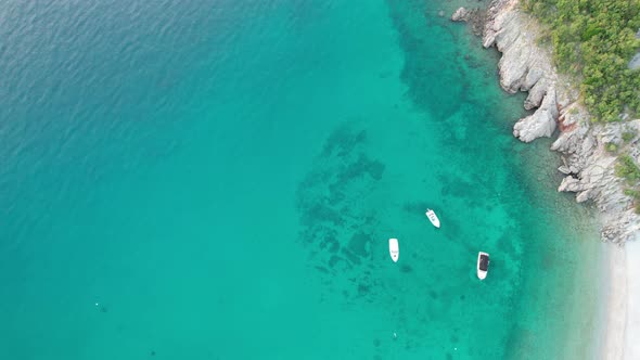 Aerial Top View of Blue Transparent Sea with Boats on the Rocky Coast of Croatia