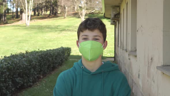 Teenager in a bright green protective medical mask in the countryside