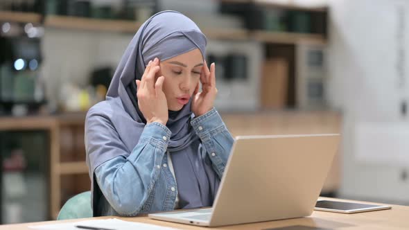 Arab Woman with Headache Using Laptop at Work