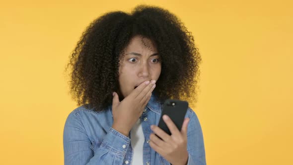 African Woman Loss on Smartphone Yellow Background