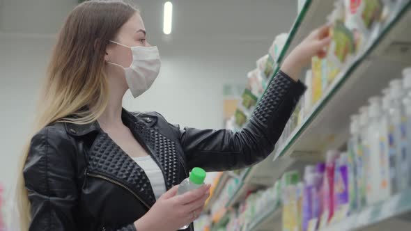 Female in Medical Mask Buying Body Care Products in Store