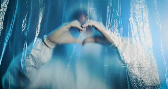 Doctor makes a heart with his hands inside covid ward