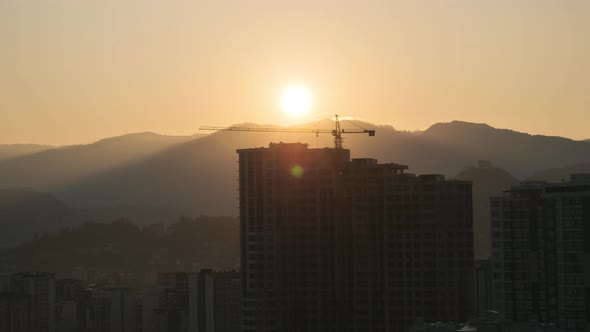 Sunrise Over a Tower Crane on Construction Site with a Skyscraper in the City. Timelapse