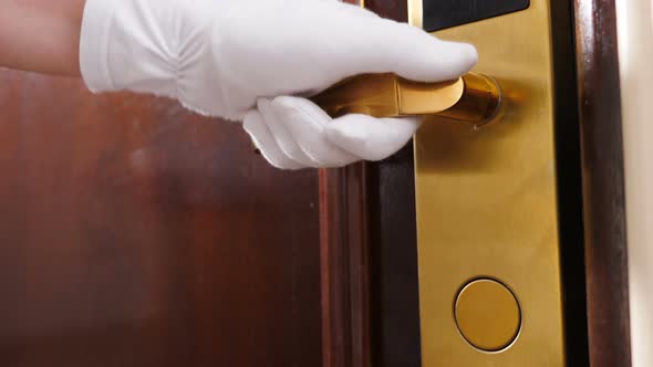 Cleaning and Hotel Concept. Close-up Shot of Maid in Gloves Opening Door Handle and Then Entering