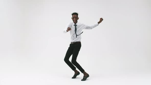 Young Black Man in an Office Suit Jumps and Rejoices on a White Background