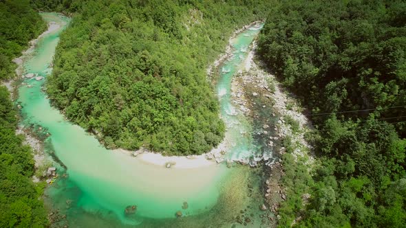 Aerial view of the calm water surrounded by nature at Soca river in Slovenia.